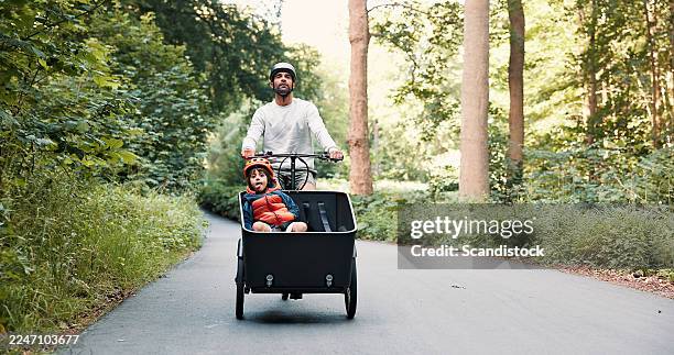 cargo bike, child and father with travel outdoor for eco friendly ride, exploring forest road or bonding. safety, dad or boy kid with bicycle in nature for cycling, sustainable transport or adventure - pedestrian walkway stock pictures, royalty-free photos & images