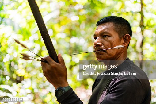 Indigenous person from the Curripaco tribe using a Zarabatana on the forest in Guainía, Colombia Indigenous person from the Curripaco tribe using a Zarabatana on the forest in Guainía, Colombia