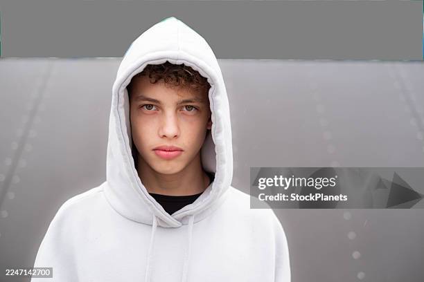 chico adolescente con sudadera blanca con cara seria - camisa con capucha fotografías e imágenes de stock