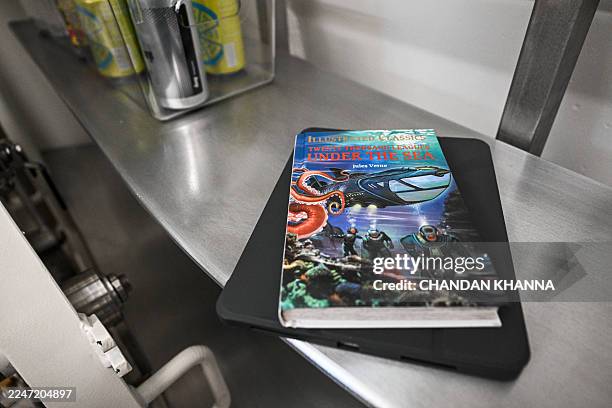 Book by Jules Verne is seen inside ocean engineering and technology development company DEEP's pilot subsea human habitat, Vanguard, as it is...