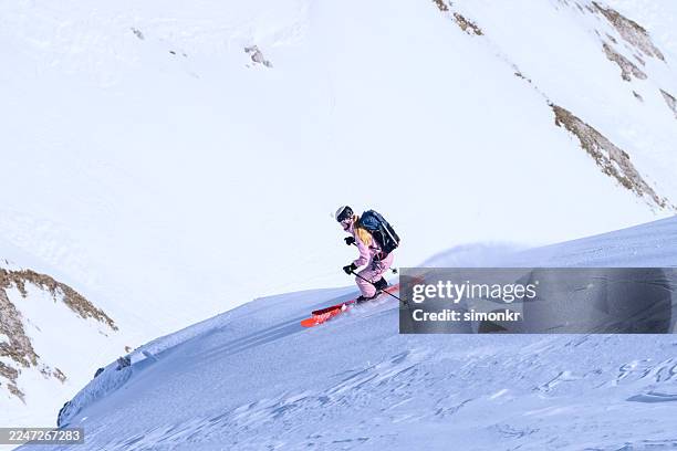 caucasian woman skiing down alpine slope with joyful enthusiasm - telemarken stockfoto's en -beelden