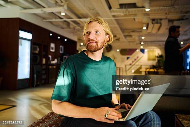 young adult man programming on laptop in modern office - problem solving stock pictures, royalty-free photos & images