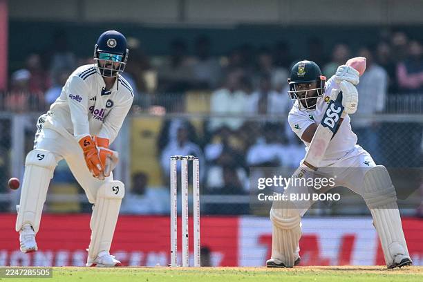 South Africa's captain Temba Bavuma plays a shot as India's captain Rishabh Pant watches during the first day of the second Test cricket match...