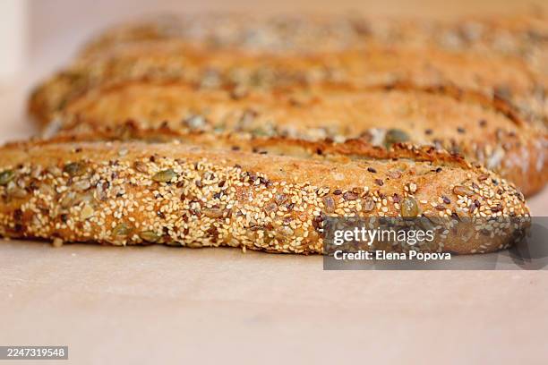 freshly baked wholegrain baguettes with pumpkin seeds, white and black sesame - vollkornbrot stock-fotos und bilder