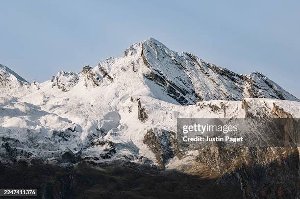 a dramatic long lens view onto a snow capped mountain ridge high up in the french pyrenees on an autumnal morning - coberto de neve imagens e fotografias de stock