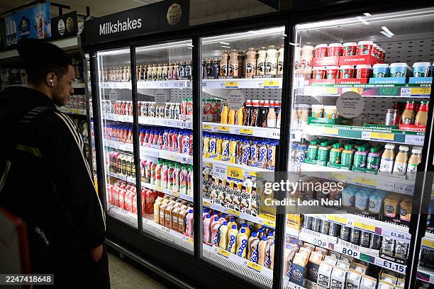 Range of flavoured milkshakes are displayed in the chilled goods aisle of a branch of the Tesco chain of supermarkets on November 19, 2025 in London,...