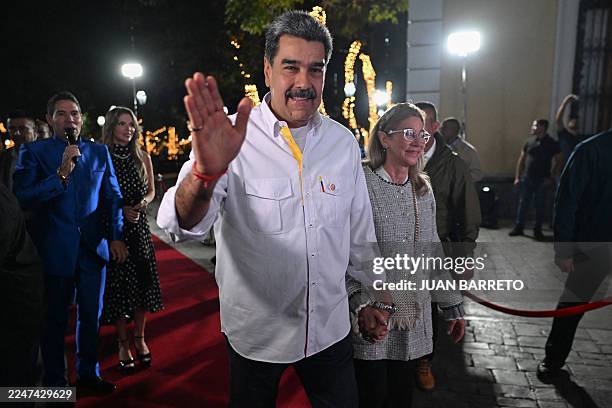 Venezuela's President Nicolas Maduro and his wife Cilia Flores wave to supporters as they arrive for the screening of a biographical series at the...