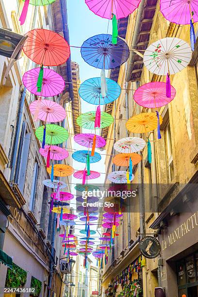 multicolored umbrellas hanging above street as a colorful decoration - installation art stock pictures, royalty-free photos & images