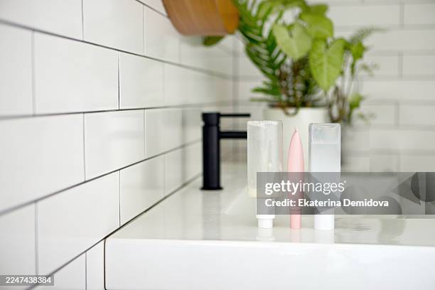 modern bathroom sink with minimalist skincare products - toiletries stock pictures, royalty-free photos & images