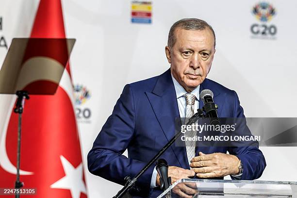 Turkey's President Recep Tayyip Erdogan buttons up his jacket during a press conference after the conclusion of the G20 Leaders' Summit at the Nasrec...