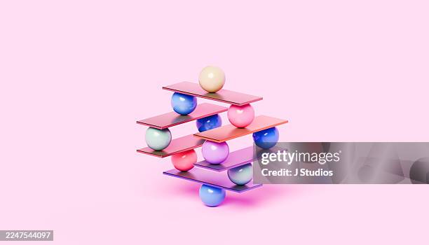 colorful spheres and plates in impossible precarious balance stack - sharp stock pictures, royalty-free photos & images