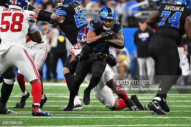 Detroit Lions running back David Montgomery runs though an attempted by New York Giants defensive end Chauncey Golston tackle during the Detroit...
