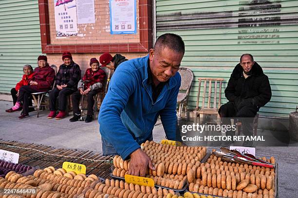 This photo taken on November 20, 2025 shows a vendor selling cookies on a street in Dingnan County, Ganzhou, in east China's Jiangxi province.