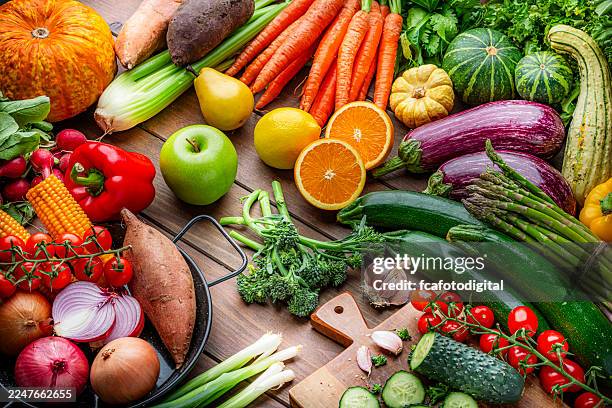 freshly picked organic fruits and vegetables on kitchen table. preparing healthy vegetarian meal with juicy ingredients. food to improve the inmune system. - vegetable stock pictures, royalty-free photos & images