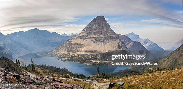 panoramic view of hidden lake overlook at glacier national park, montana, with bearhat mountain, a blue alpine lake, rocky foreground, and a vast forested valley under an expansive sky - rock strata stock pictures, royalty-free photos & images