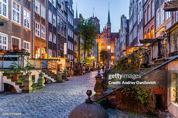 wide-angle view of mariacka street with greenery and stone terraces in the evening. - gdansk stock pictures, royalty-free photos & images