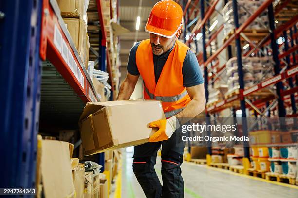 lagerarbeiter hebt kiste aus dem regal - box lifting technique stock-fotos und bilder