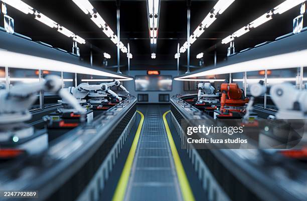 industrielle roboterarme in einer hightech-fabriklinie mit förderbändern und heller deckenbeleuchtung - fließbandfertigung stock-fotos und bilder