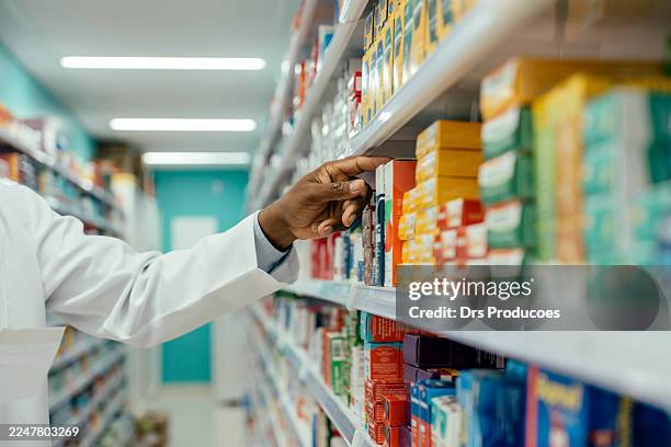farmacéutico revisando medicamentos en la estantería de la farmacia. - material médico fotografías e imágenes de stock