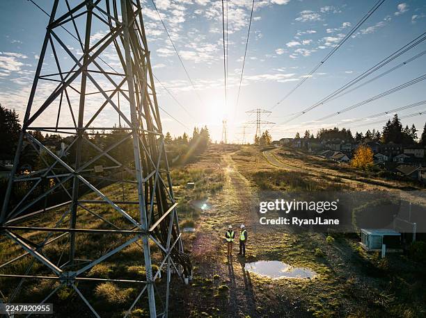 aerial view of utility power line workers examining electrical pylons - elnät bildbanksfoton och bilder