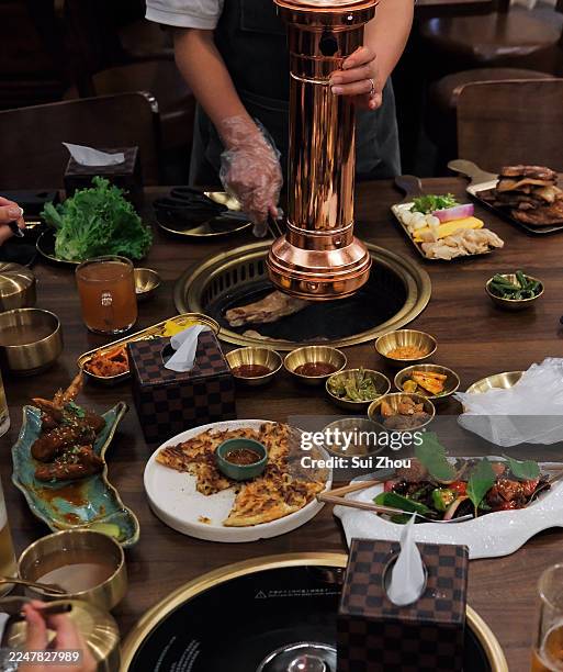 korean bbq dining experience with shared dishes and tabletop grilling - thimphu stock pictures, royalty-free photos & images