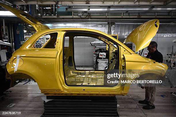 An employee of auto giant Stellantis works on the 500 Hybrid assembly line at the car maker Mirafiori factory in Turin, during the presentation of...
