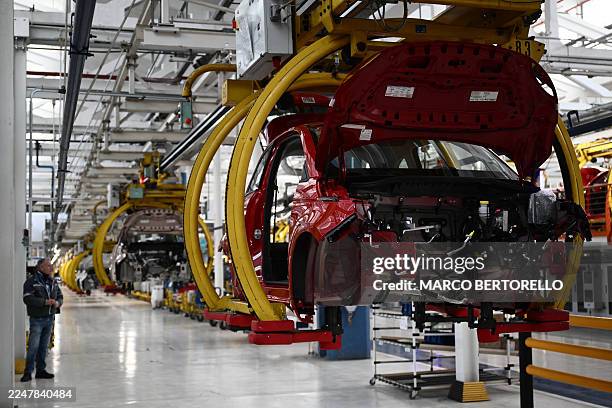 An employee of auto giant Stellantis works on the Fiat 500 Hybrid assembly line at the car maker Mirafiori factory in Turin, during the presentation...