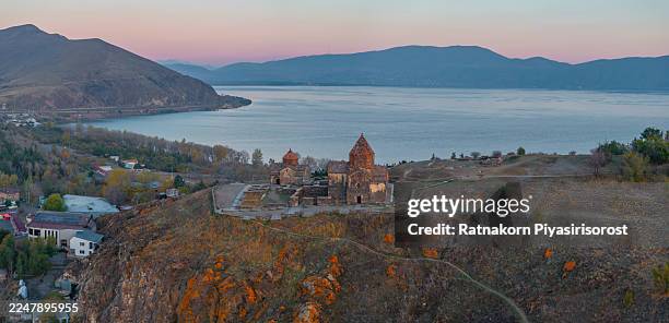 the historic 9th-century sevanavank monastery, an iconic landmark on the shores of lake sevan, armenia, is silhouetted against a spectacular golden sunrise. - sevanavank monastery stock pictures, royalty-free photos & images