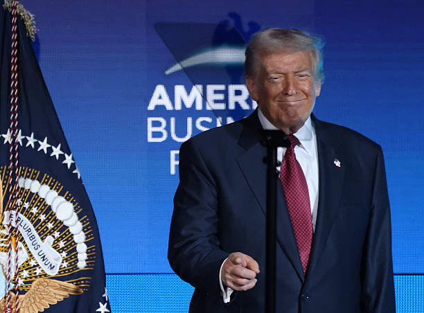 President Donald J. Trump smiles after walking on stage to address the attendees of the American Business Forum at the Kaseya Center in Miami on...