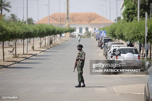 Soldier holds his weapon while patrolling a street near the scene of gunfire near the Presidential Palace in Bissau on November 26, 2025. Gunfire was...