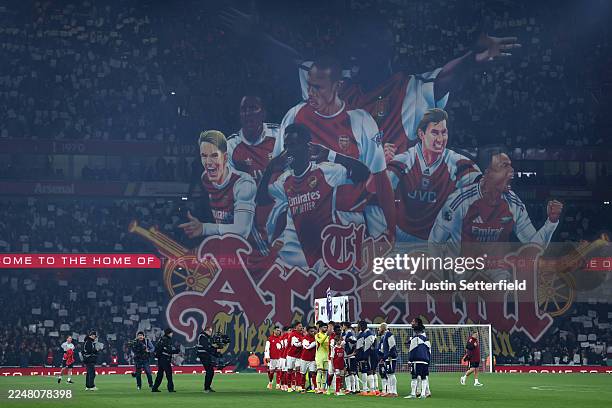 Players of Arsenal and Tottenham Hotspur shake hands as the fans unveil a tifo prior to the Premier League match between Arsenal and Tottenham...
