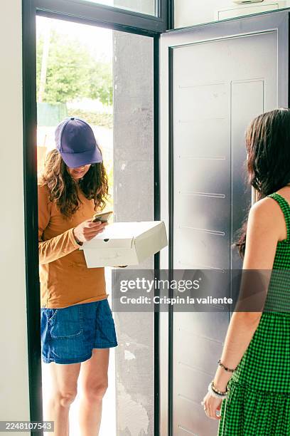 delivery woman delivering package to a customer at home - contactless delivery stock pictures, royalty-free photos & images