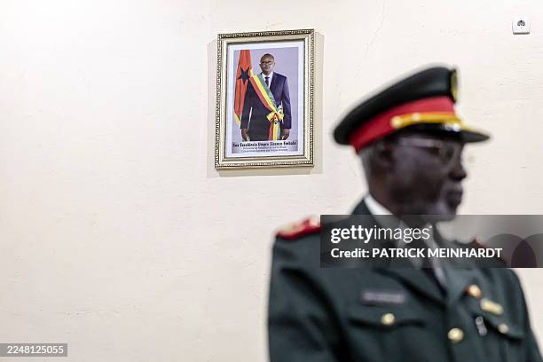 Advisor to the High Military Commander Malam Camara stands next to a portrait of deposed Guinea Bissau President Umaro Sissoco Embalo during the...