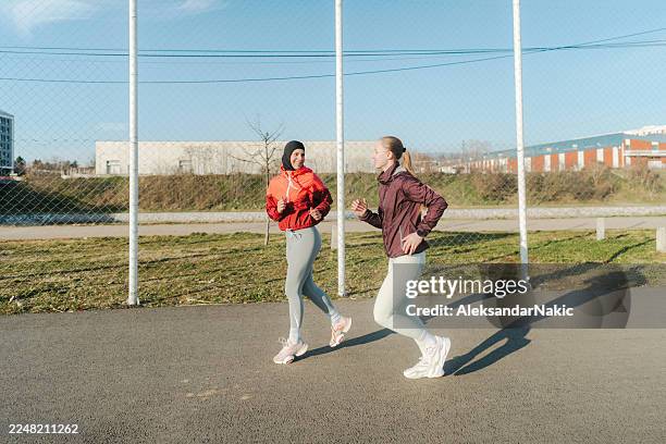 two women jogging together - religious veil stock pictures, royalty-free photos & images