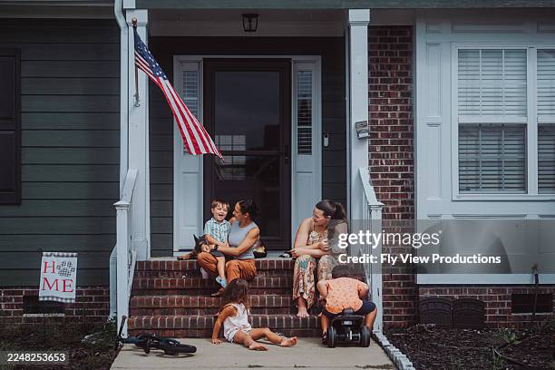 zwei frauen mit kindern unterhalten sich auf der vorstadtveranda - amerikanische südstaaten flagge stock-fotos und bilder