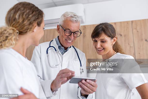 senior doctor with young female trainees on specialization - loading doc stock pictures, royalty-free photos & images