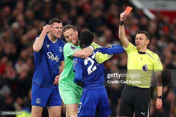 Idrissa Gana Gueye of Everton is shown a red card by Referee Tony Harrington after clashing with teammate Michael Keane as he is restrained by Jordan...