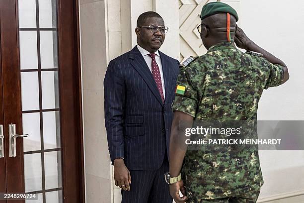 Newly appointed Prime Minister and Finance Minister of the transitional government Ilidio Vieira Te salutes a high ranking officer from the Guinea...