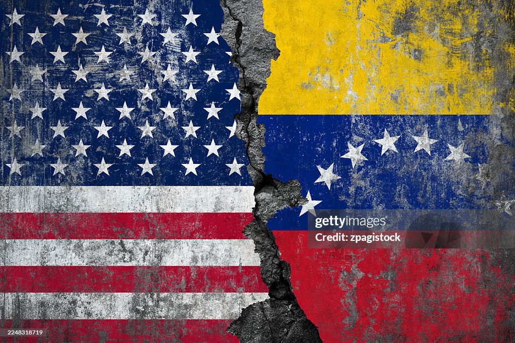 American and Venezuelan flags painted on a cracked concrete wall showing the deep divide and separation between USA and Venezuela