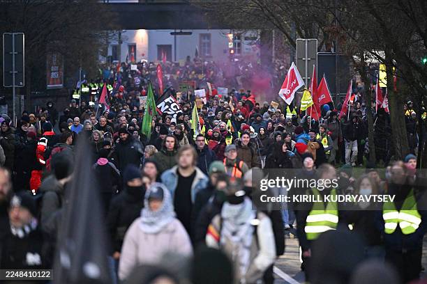 Demonstrators march with banners and flags during a protest against a two-day convention of far-right Alternative for Germany party to establish its...