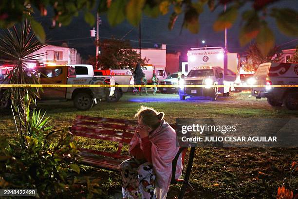 Woman reacts outside a house where clandestine fireworks were being manufactured, after an explosion left three people dead and six injured, in the...