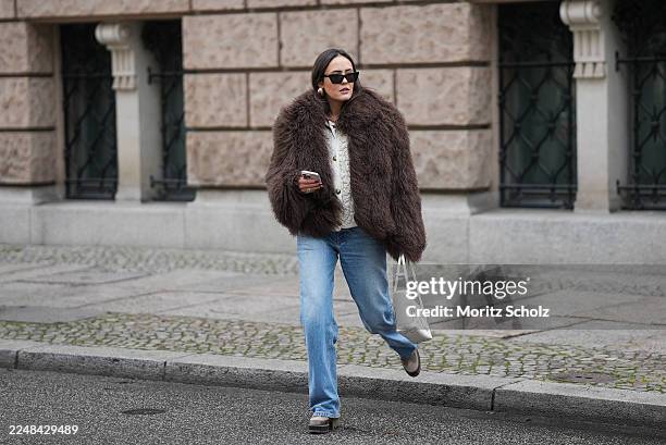Laura Noltemeyer is seen wearing a dark-brown oversized shearling-effect faux-fur jacket with a voluminous, curly texture and wide collar from Ducie...