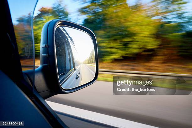 blurred sideview out of car's window on side mirror at sunrise - wing mirror stock pictures, royalty-free photos & images