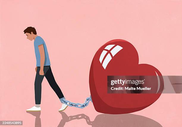 large red heart shackled to ankle of dejected man on pink background - miteinander verbunden stock-grafiken, -clipart, -cartoons und -symbole
