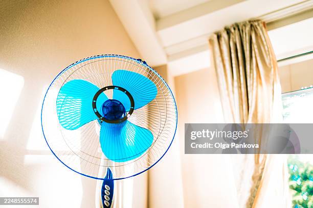blue electric fan cooling room during summer heat - electric fan stock pictures, royalty-free photos & images