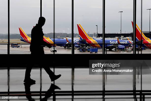 Travelers walk by airplanes with Southwest Airlines on the tarmac at the Baltimore/Washington International Thurgood Marshall Airport on November 26,...