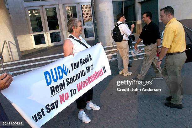 View of protesters with PROTECTS as they hold a banner during, a Dell Computing shareholder meeting, outside the Austin Convention Center, Austin,...