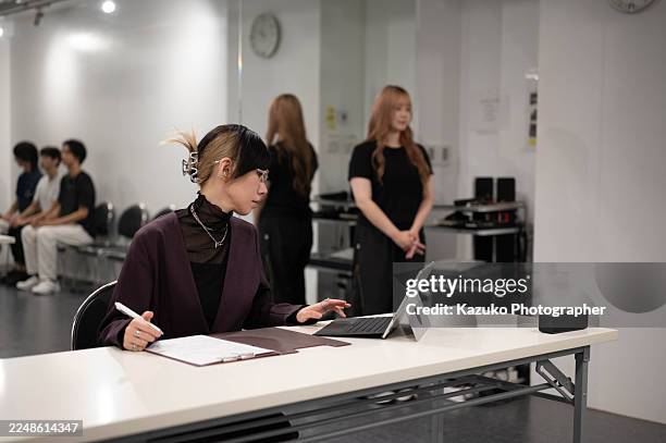 a female judge looks at the audition evaluation report with a serious expression - audition stock pictures, royalty-free photos & images