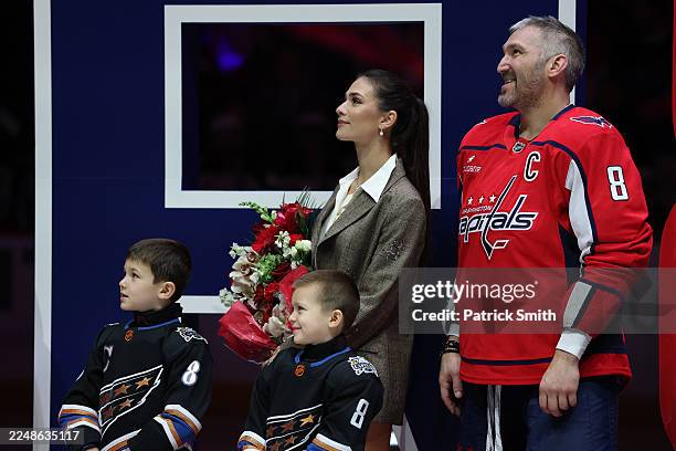 Alex Ovechkin of the Washington Capitals stands with wife Nastya Ovechkin and sons Ilya Ovechkin and Sergei Ovechkin as he is honored for scoring 900...