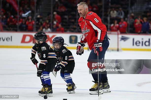 Alex Ovechkin of the Washington Capitals skates with his sons Ilya Ovechkin and Sergei Ovechkin during warmups before playing against the Winnipeg...